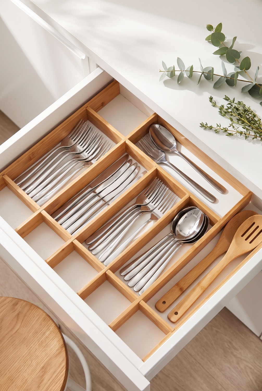 Bamboo drawer organiser with neatly arranged cutlery in a bright Scandinavian kitchen