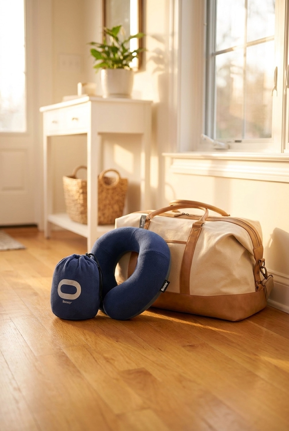 travel neck pillow beside a packed bag in a bright entryway in soft golden-hour light